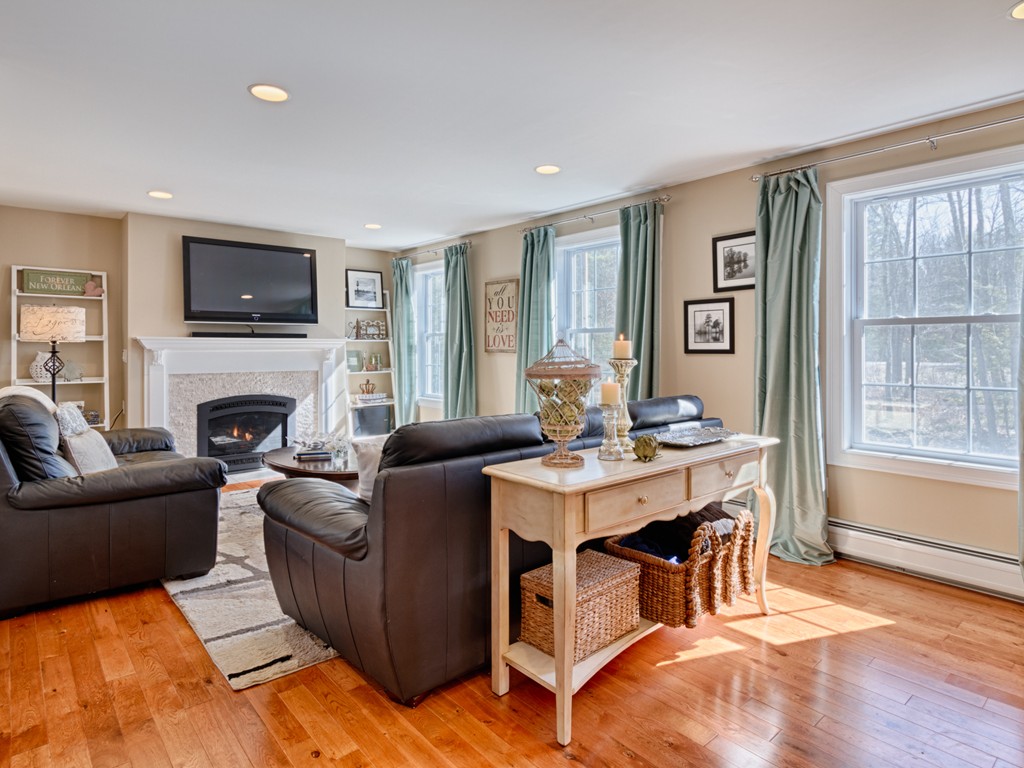 69 Ledge Road, Unit 69 Seabrook, NH 03874 - Photo 12 of 17 a living room with furniture a flat screen tv and a fireplace