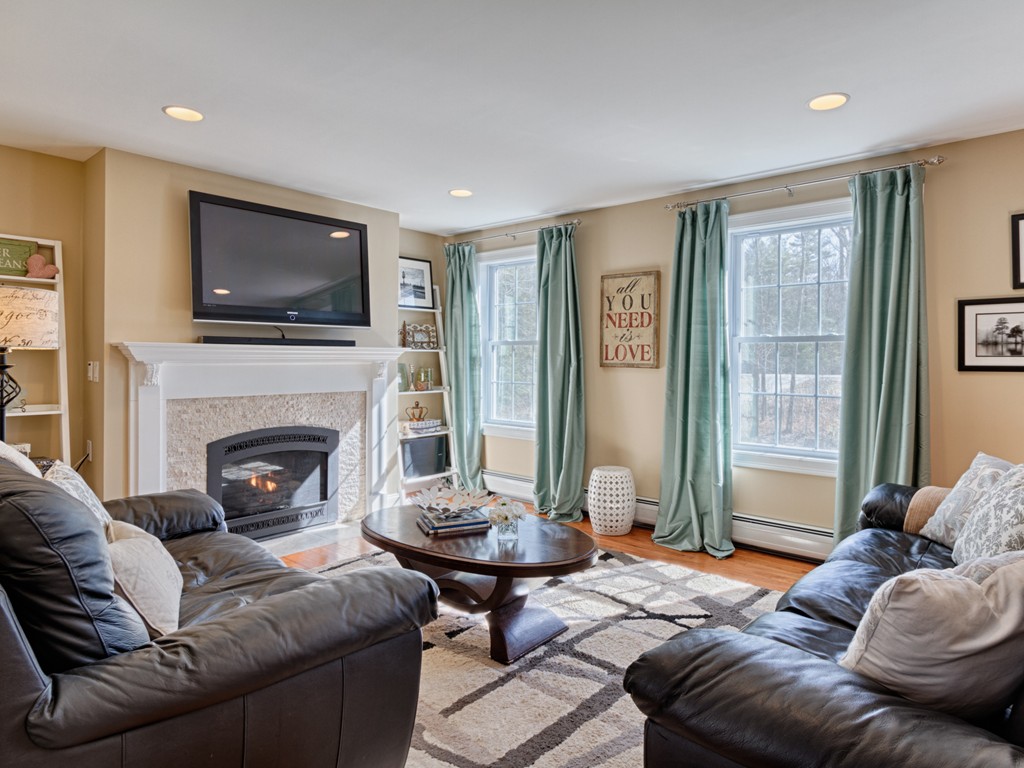 69 Ledge Road, Unit 69 Seabrook, NH 03874 - Photo 13 of 17 a living room with furniture a flat screen tv and a fireplace