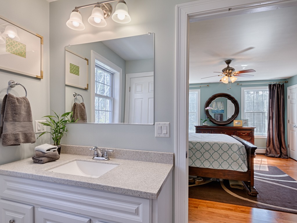 69 Ledge Road, Unit 69 Seabrook, NH 03874 - Photo 14 of 17 a en suite bathroom with a granite countertop sink and a mirror