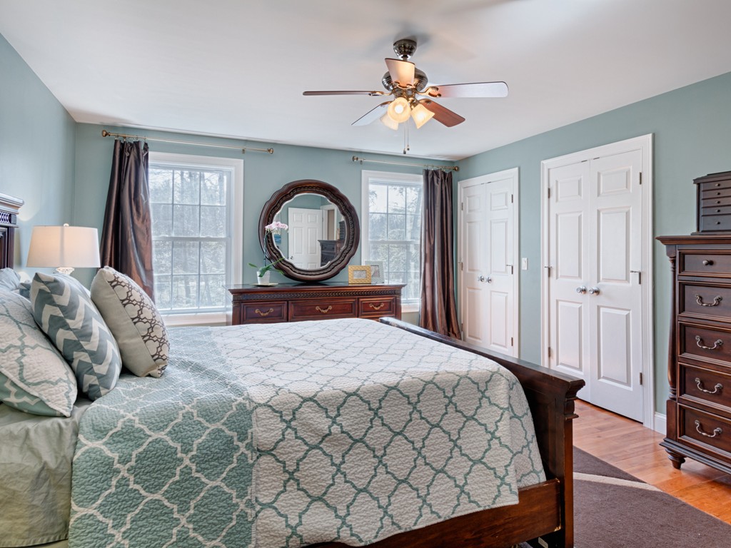 69 Ledge Road, Unit 69 Seabrook, NH 03874 - Photo 17 of 17 a bedroom with a bed a dresser and a chandelier