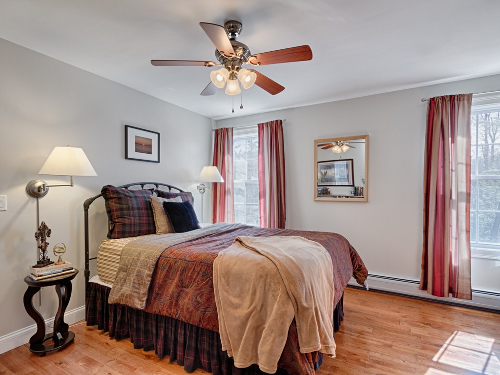 69 Ledge Road, Unit 69 Seabrook, NH 03874 - Photo 3 of 17 a bedroom with a bed and wooden floor