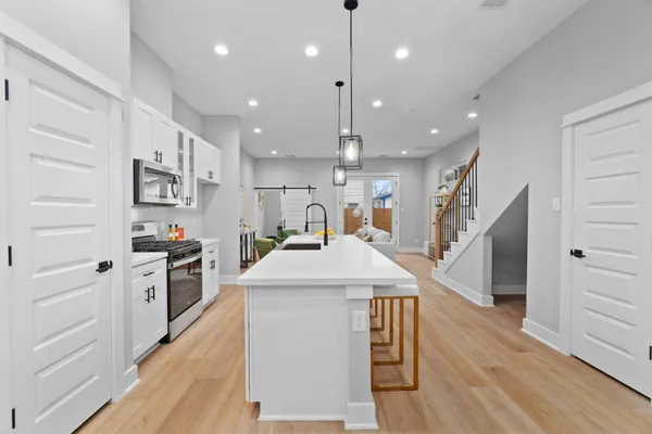 a kitchen with kitchen island a stove a sink a refrigerator and a center island
