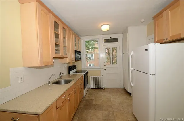 a kitchen with a refrigerator a sink and cabinets