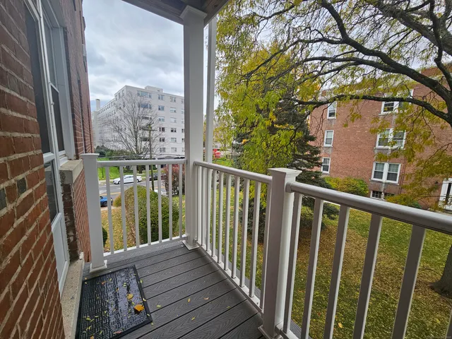 a view of a balcony with wooden floor and fence