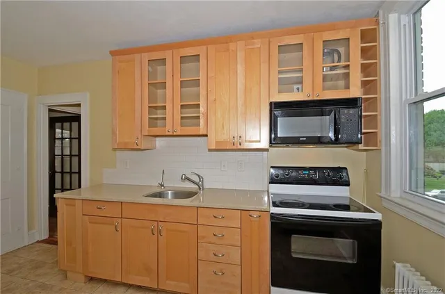 a kitchen with stainless steel appliances white cabinets and a stove top oven