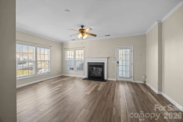 an empty room with windows and fireplace