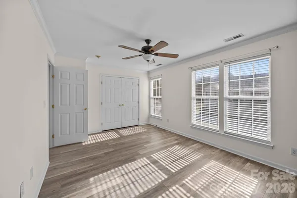 a view of a livingroom with a ceiling fan & windows