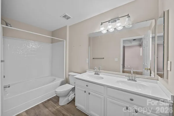 a bathroom with a sink a toilet and a large mirror