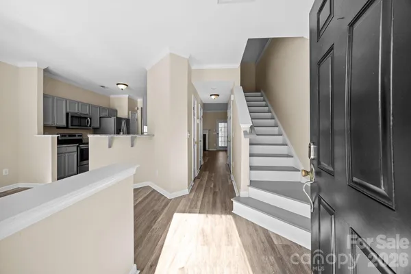 a view of a kitchen with wooden floor and electronic appliances