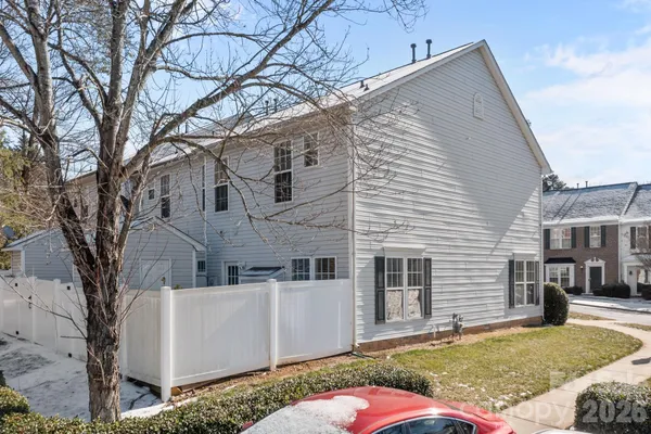 a view of a white house with a large tree