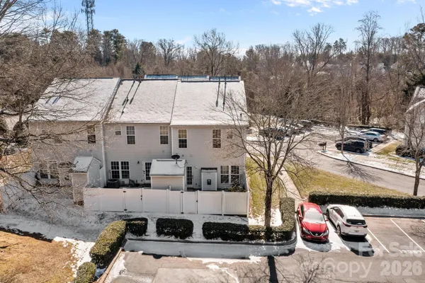 a view of a white house with large windows and a yard