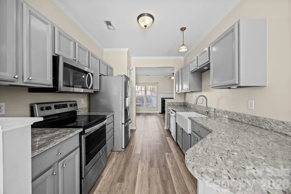 a kitchen with stainless steel appliances granite countertop a sink stove microwave and cabinets