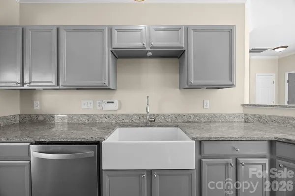 a kitchen with granite countertop a sink and cabinets