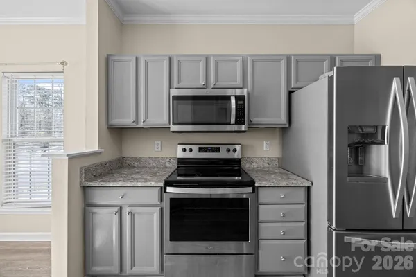 a kitchen with granite countertop a refrigerator stove and microwave