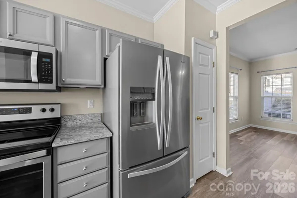 a kitchen with granite countertop a refrigerator and a stove top oven
