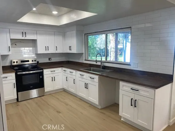 a kitchen with granite countertop white cabinets and white appliances