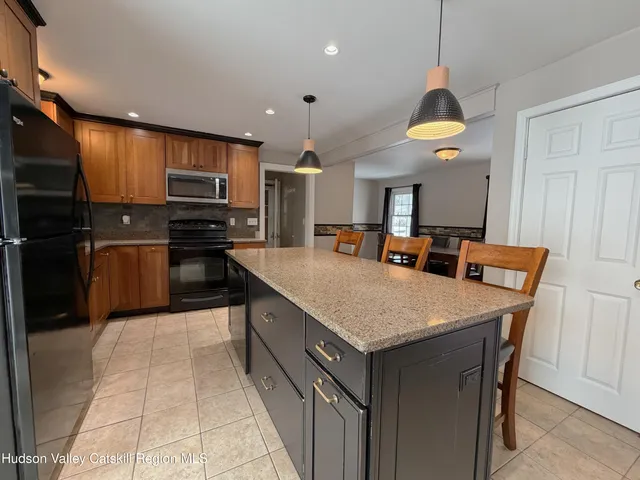 a kitchen with stainless steel appliances granite countertop a sink a stove and a refrigerator