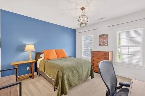a bedroom with a bed and a chandelier