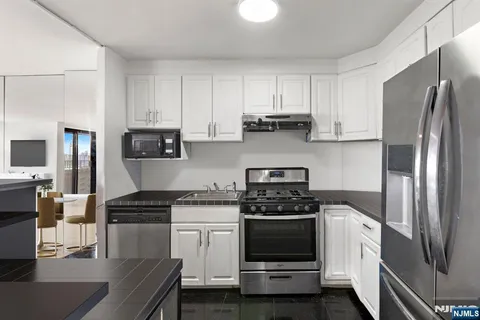 a kitchen with white cabinets and stainless steel appliances