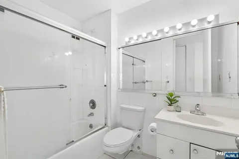 a bathroom with a sink a toilet a shower and a mirror