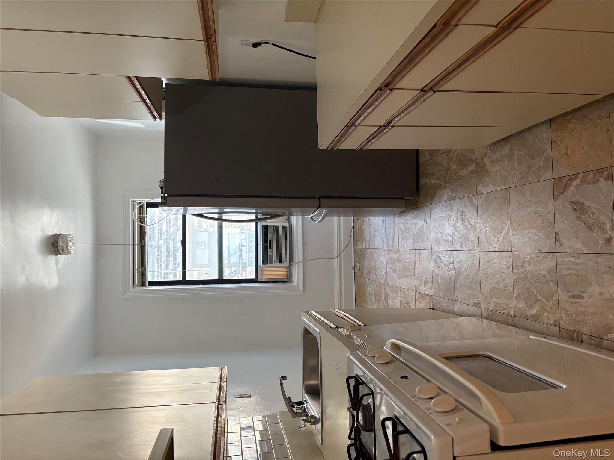 5005 43rd Avenue, Unit 5H Queens, NY 11377 - Photo 11 of 23 Kitchen featuring stove, stainless steel refrigerator, light countertops, tasteful backsplash, and light stone finish flooring