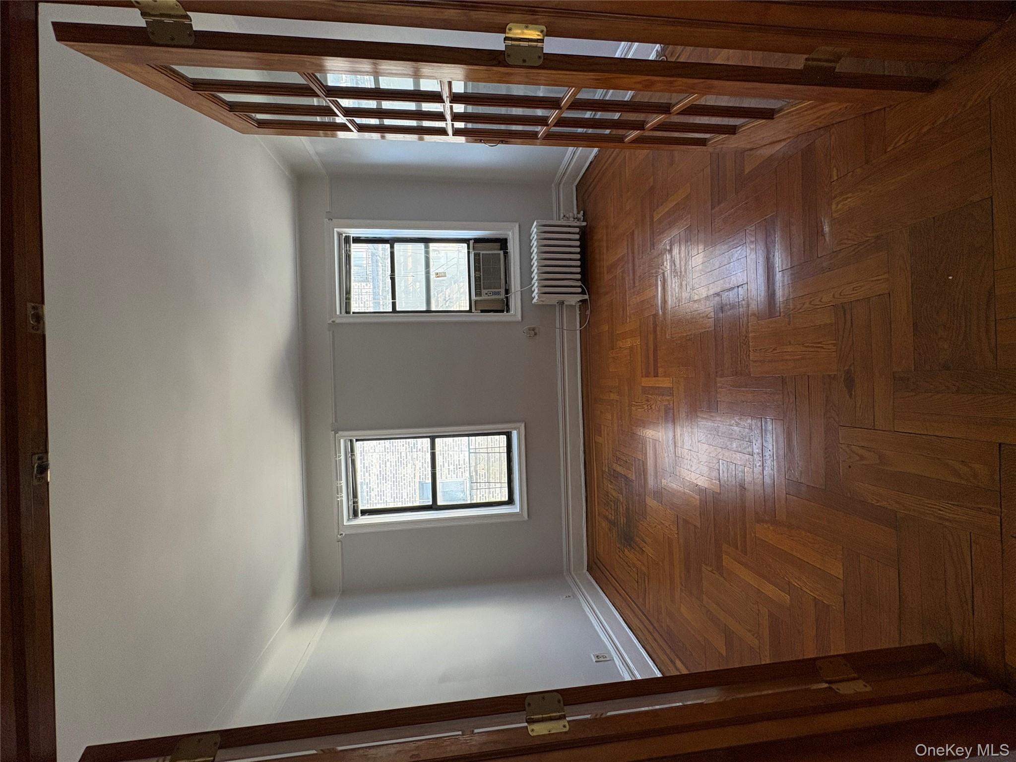 5005 43rd Avenue, Unit 5H Queens, NY 11377 - Photo 16 of 23 Empty room with plenty of natural light, radiator, and french doors