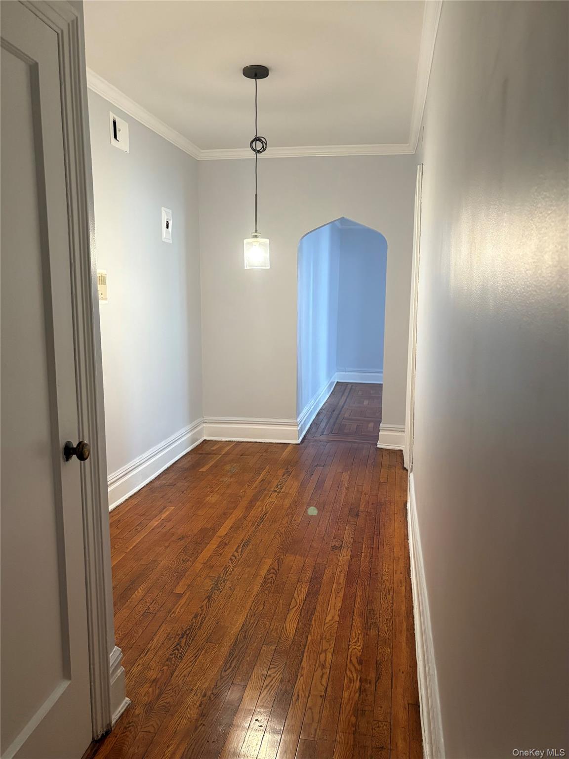 5005 43rd Avenue, Unit 5H Queens, NY 11377 - Photo 10 of 23 Spare room with dark wood-style flooring, crown molding, and arched walkways