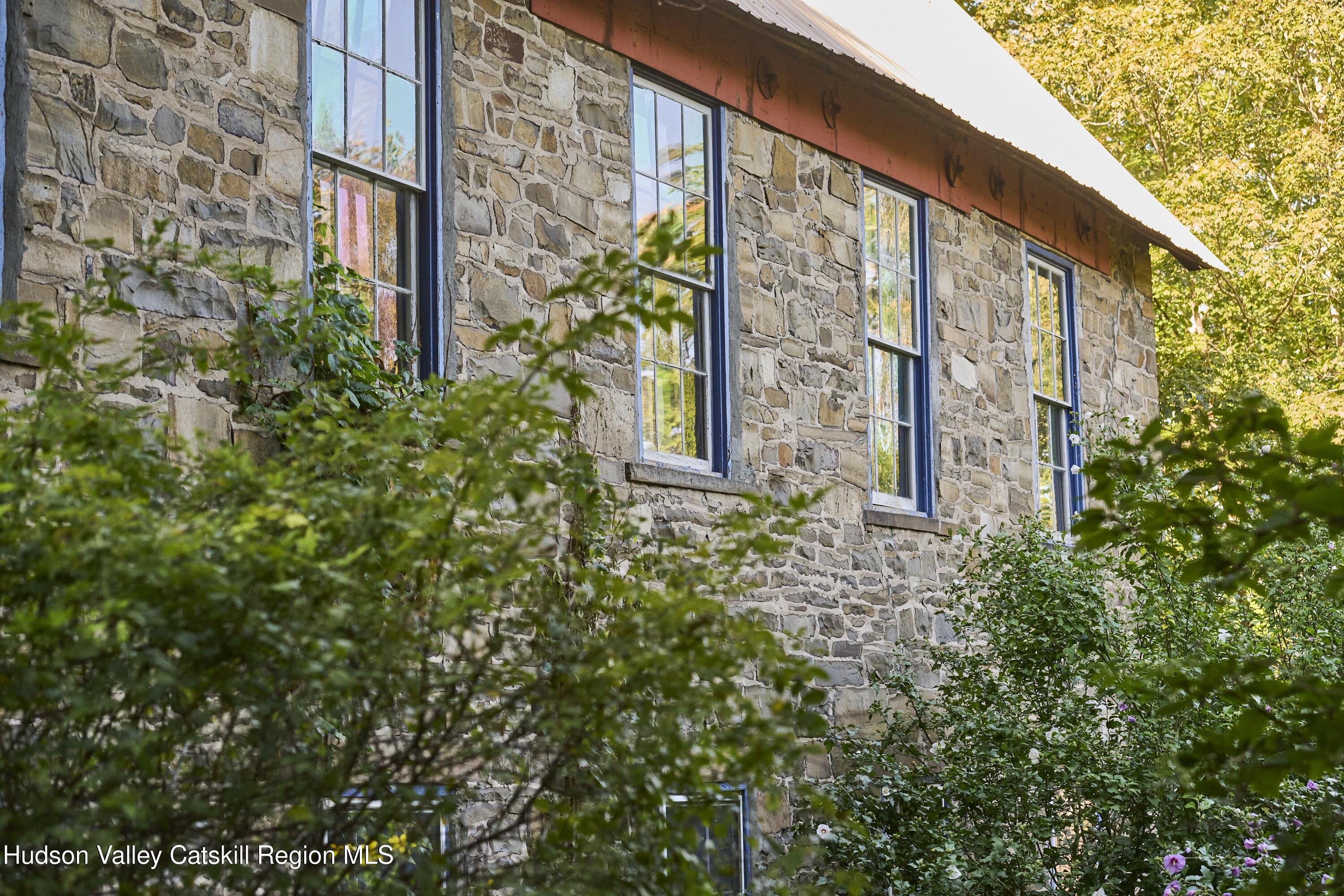 1883 Highway 213 Rifton, NY 12471 - Photo 47 of 50 a view of a brick wall with plants and large windows