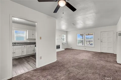 an empty room with windows and cabinet