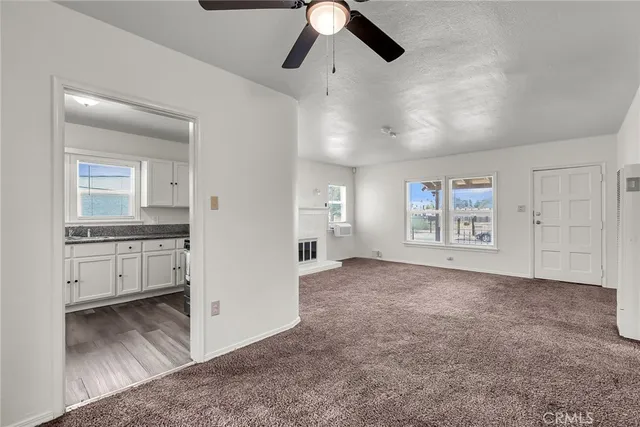 an empty room with windows and cabinet