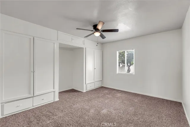 a view of a livingroom with a ceiling fan and window