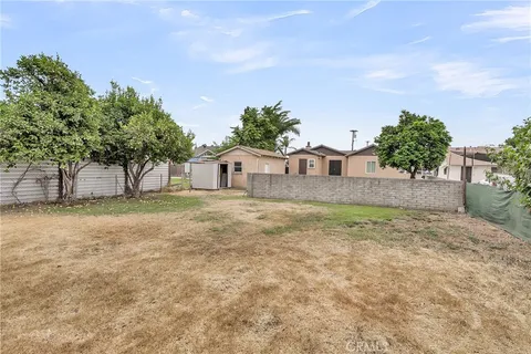 a backyard of a house with plants and tree