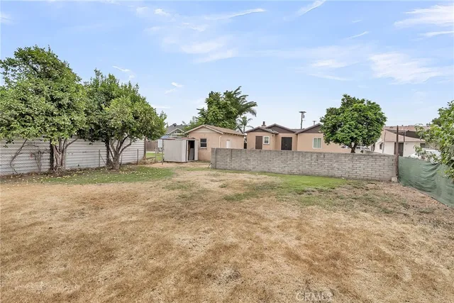 a backyard of a house with plants and tree