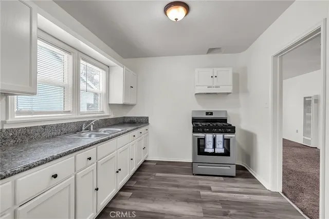 a kitchen with granite countertop a stove and a sink