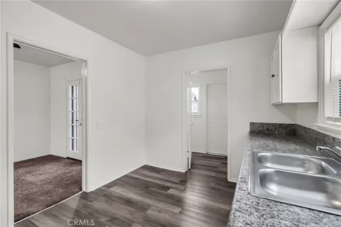 a kitchen with granite countertop a sink and a stove top oven