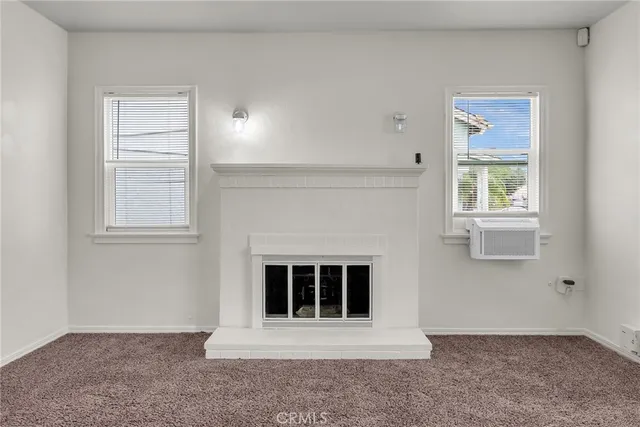 an empty room with a fireplace and a window