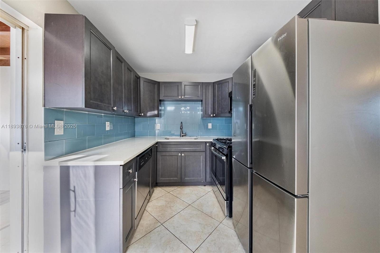 3589 Island Road Palm Beach Gardens, FL 33410 - Photo 11 of 40 a kitchen with a refrigerator a sink and cabinets