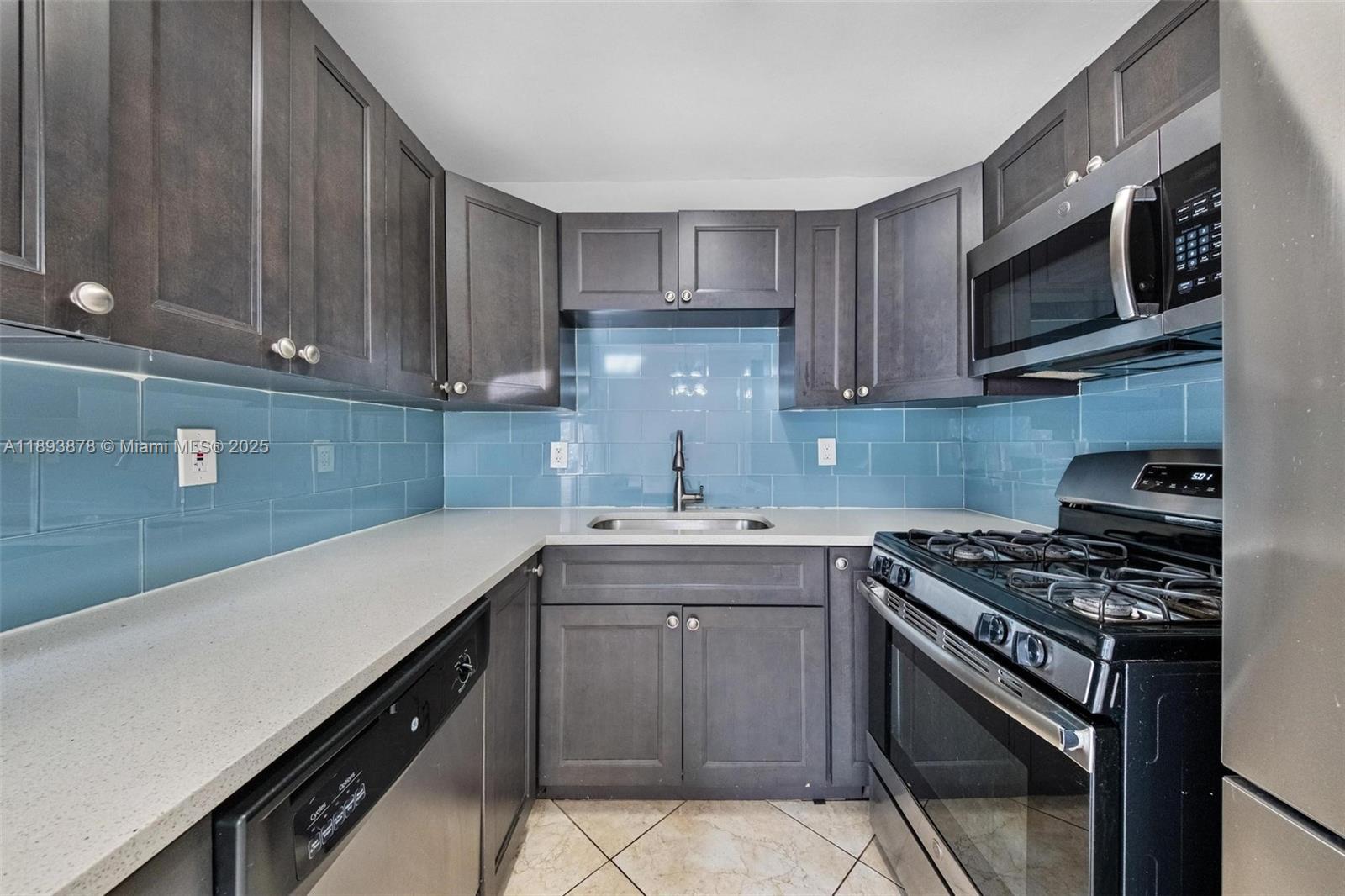 3589 Island Road Palm Beach Gardens, FL 33410 - Photo 12 of 40 a kitchen with stainless steel appliances a sink dishwasher stove top oven and cabinets