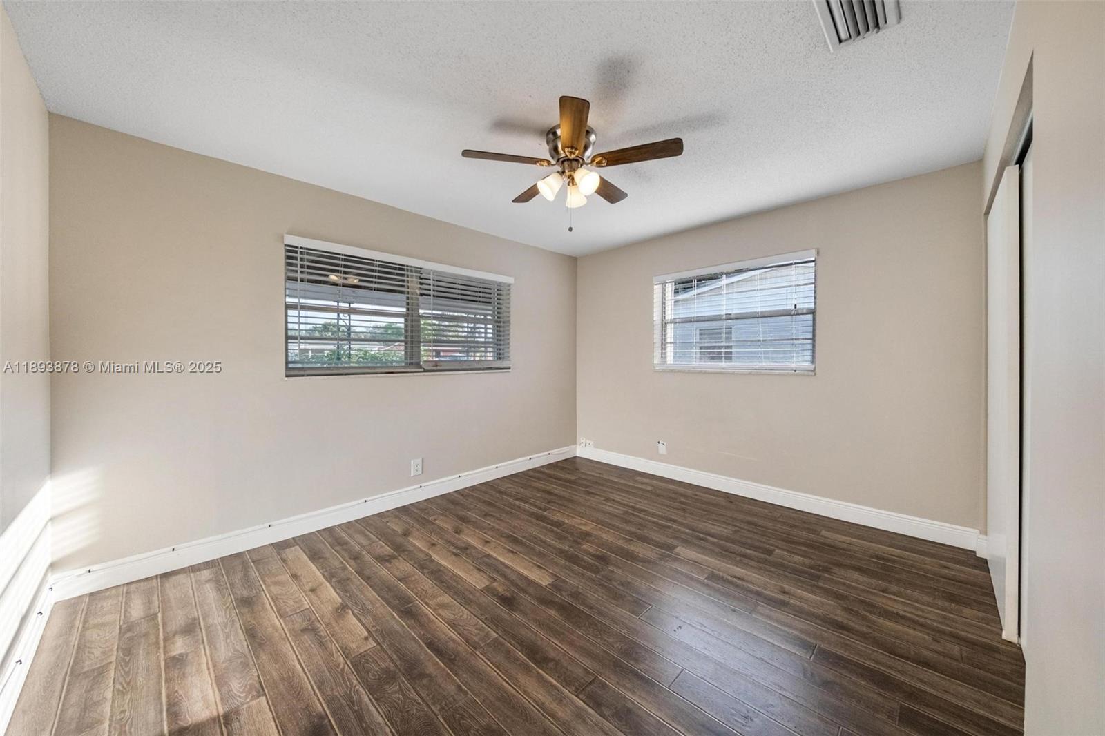 3589 Island Road Palm Beach Gardens, FL 33410 - Photo 29 of 40 a view of an empty room with wooden floor and a window