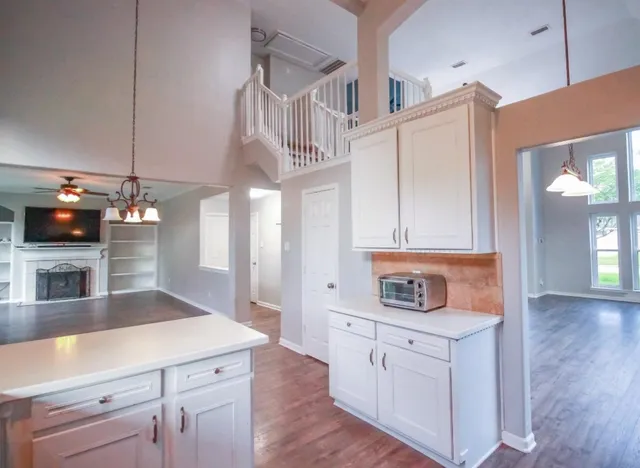a kitchen with cabinets and wooden floor