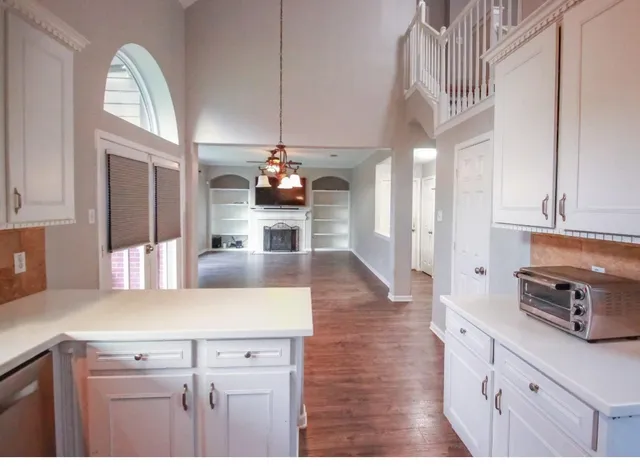 a kitchen with stainless steel appliances kitchen island granite countertop a sink cabinets and wooden floor