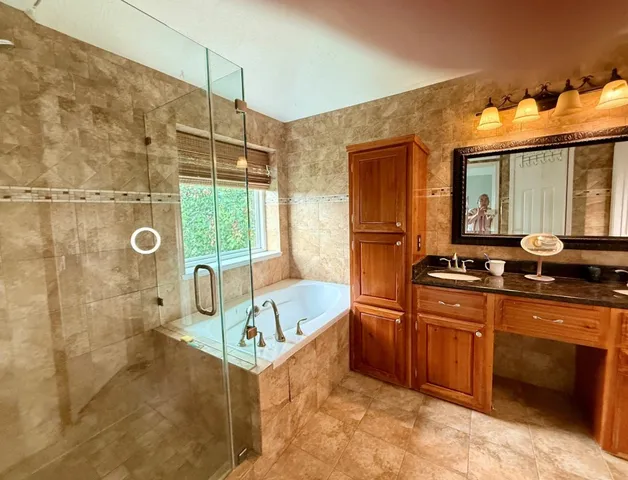 a bathroom with a tub sink and mirror