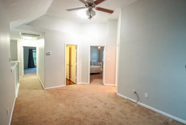 a view of a room with a ceiling fan and a bathroom