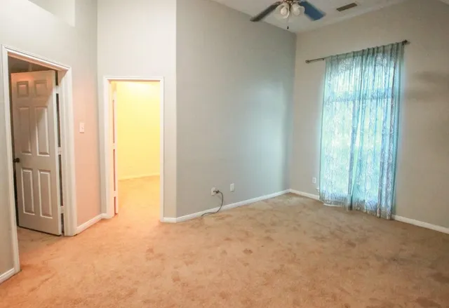 an empty room with windows and closet