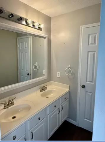 a bathroom with a double vanity sink and mirror