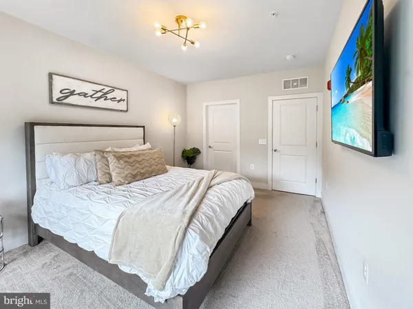 a spacious bedroom with a bed and a lamp