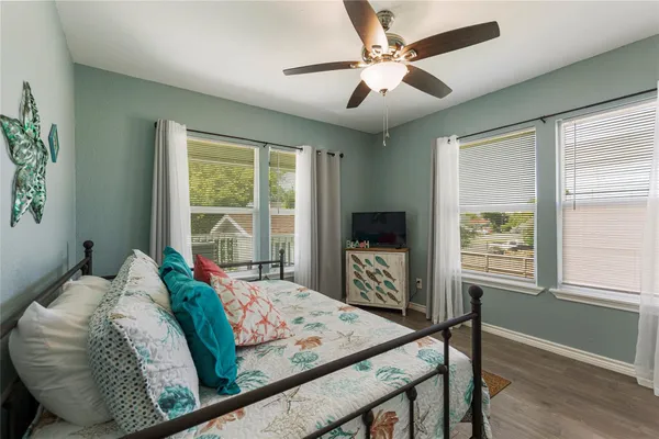 a bedroom with a bed a window and a flat screen tv