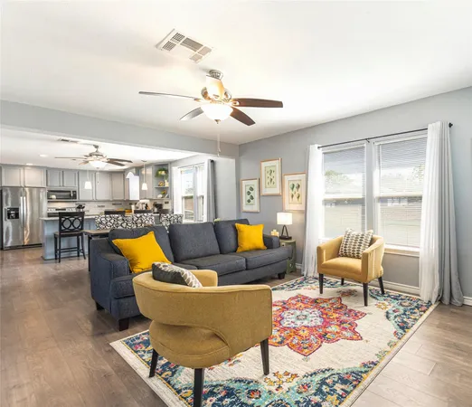 a living room with furniture kitchen view and a large window
