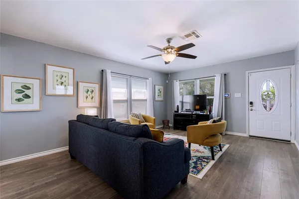 a living room with furniture and wooden floor