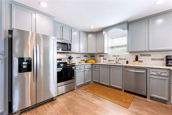 a kitchen with a refrigerator cabinets and wooden floor